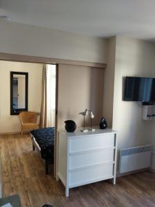 een kamer met een dressoir en een tv aan de muur bij Suit'home in Fort-Mahon-Plage