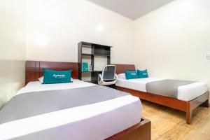 1 dormitorio con 2 camas y escritorio en Ayenda Casa Alvarez, en Bogotá