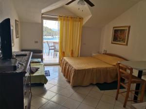 a bedroom with a bed and a television and a balcony at Villa Rosa in Vela Luka