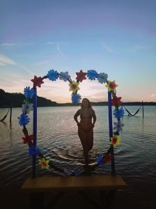 a woman standing in the water in the ocean at Hostel Das Canárias in Natal