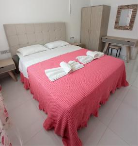 アリケスにあるMarion Holiday Houseのベッドルーム1室(ピンクベッド1台、タオル2枚付)