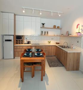 a kitchen with white cabinets and a wooden table at Marion Holiday House in Alykes