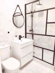 een witte badkamer met een toilet en een douche bij Aéroport Roissy CDG - Parc Astérix - Parc des expositions in Louvres