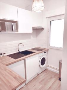 a kitchen with a sink and a washing machine at Aéroport Roissy CDG - Parc Astérix - Parc des expositions in Louvres