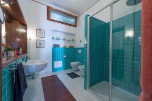 a bathroom with a sink and a shower with green tiles at Bellavista di Conca in Conca dei Marini +19 photos