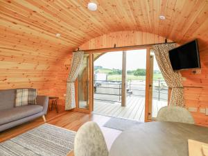 a living room with a wooden ceiling with a large window at Bluebell in Rhayader