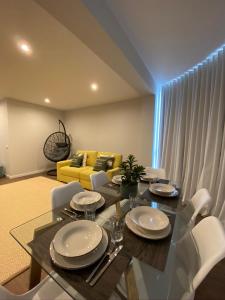 a dining room with a glass table and white chairs at Santuário Fátima - Host 2AP5 in Fátima