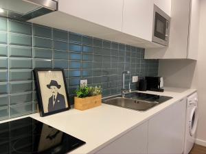 a kitchen with a sink and a picture of a man at Santuário Fátima - Host 2AP5 in Fátima