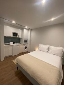a bedroom with a large bed and a kitchen at Santuário Fátima - Host 2AP5 in Fátima