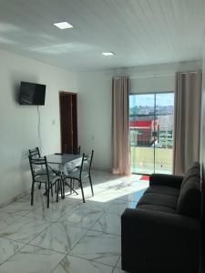 a living room with a table and chairs and a couch at Lindo Apartamento ! in Manaus