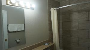 a bathroom with a shower with a mirror at La Villita Inn in San Antonio