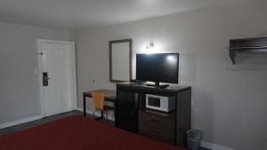a room with a tv on a dresser with a microwave at La Villita Inn in San Antonio +48 photos