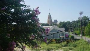 a house on the side of a street with purple flowers at La Villita Inn in San Antonio