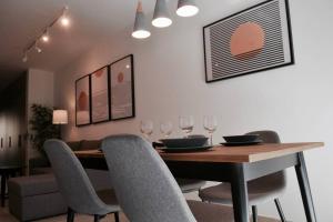 una sala da pranzo con tavolo, sedie e bicchieri da vino di Sliema, Stylish 2 Bedroom Apartment with Parking a Sliema