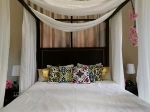 uma cama branca com almofadas em cima em Kaleidoscope em Ajman