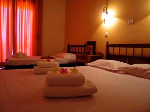 a hotel room with two beds and two lamps at Kissamos Hotel in Kissamos