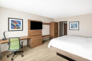 a hotel room with a bed desk and a television at Holiday Inn Express & Suites - Phoenix - Airport North, an IHG Hotel in Phoenix