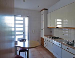 a kitchen with a wooden table and a sink and a table at Casa de Santo Amaro in Vila do Conde