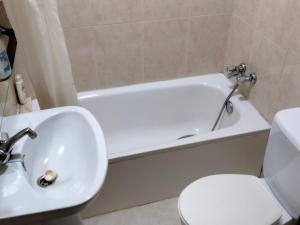 La salle de bains est pourvue d'une baignoire blanche, de toilettes et d'un lavabo. dans l'établissement A Casa de Lolita, à Muros