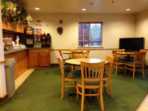 a kitchen with a table, chairs and a refrigerator at Super 8 by Wyndham Ava in Ava