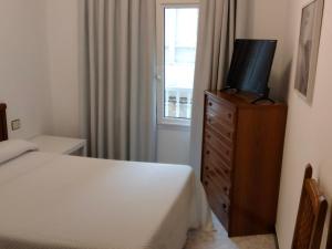ein Schlafzimmer mit einem Bett und einem TV auf einer Kommode in der Unterkunft A Casa de Lolita in Muros