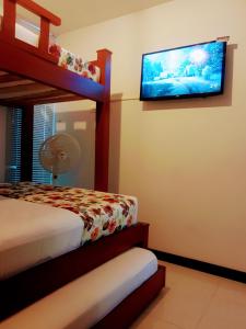 um quarto com 2 beliches e uma televisão de ecrã plano em Apartamento privado a 2 kilometros del Parque del Café em Montenegro