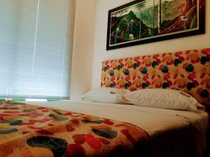 a bedroom with a bed and a painting on the wall at Apartamento privado a 2 kilometros del Parque del Café in Montenegro +19 photos