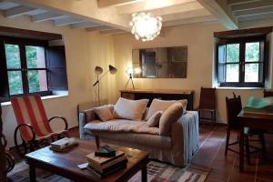 ein Wohnzimmer mit einem Sofa und einem Tisch in der Unterkunft Preciosa casona con hórreo in Ribadesella
