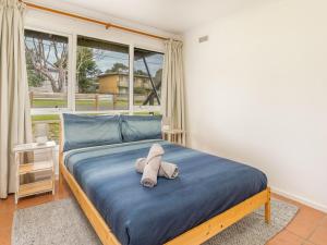 un dormitorio con una cama con un animal de peluche en Seanic at Smiths, en Smiths Beach