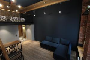 uma sala de estar com um sofá azul e um loft em Soul Kitchen Hotel em Vladivostok