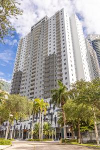 un gran edificio blanco con palmeras delante en Fortune House Hotel Suites, en Miami