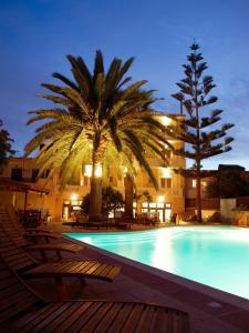 a beach with a large pool and palm trees at Kissamos Hotel in Kissamos
