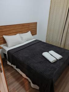 a bed with two white towels on top of it at Roof Top Bela Cintra Residence in Sao Paulo