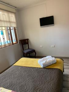 una camera da letto con un letto e una TV a parete di Casa Bachué B&B a Chía