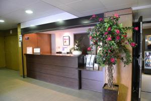 a lobby with a reception desk with flowers in at Residhotel Lyon Lamartine in Tassin-la-Demi-Lune