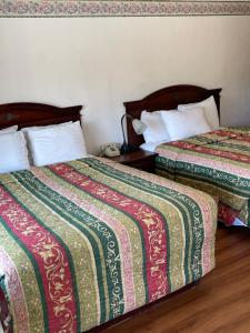 dos camas sentadas una al lado de la otra en una habitación en Villa West Motel, en Florence
