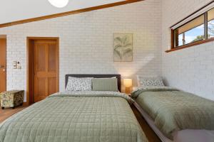 una camera da letto con due letti e un muro di mattoni di The Flaxman Studio - Panoramic Ocean Views a Port Lincoln