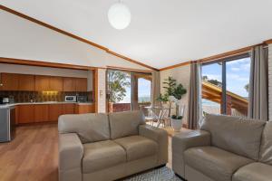 a living room with two couches and a kitchen at The Flaxman Studio - Panoramic Ocean Views in Port Lincoln
