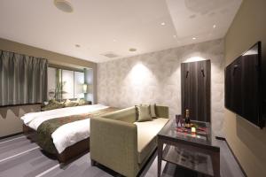 una habitación de hotel con una cama y un sofá en BAMBOO GARDEN Shinyokohama only Adult, en Yokohama
