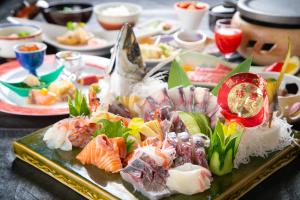 a tray of sushi on a table with plates of food at Yufuin Yasuha in Yufuin