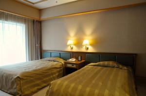 a hotel room with two beds and a window at Zazan minakami in Minakami