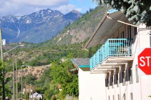 a stop sign in front of a building with mountains at Canadas Best Value Inn Mile-0-Motel Lillooet in Lillooet