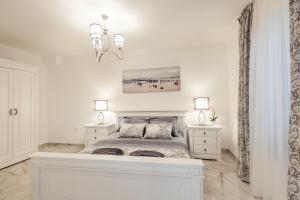 um quarto branco com uma cama e duas mesas de cabeceira em Villa Donna apartments em Herceg Novi