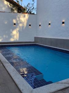 uma piscina com água azul em frente a um edifício em Flats Oliveira em Pirenópolis