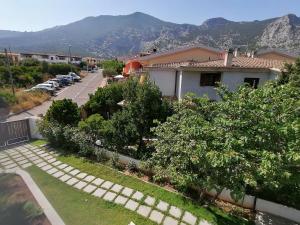 a view of a house and a street with mountains at Kind of Blue in Cala Gonone