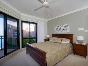 a bedroom with a bed and a ceiling fan at Seaside Splendour 1 beautiful unit on the waterfront in Salamander Bay