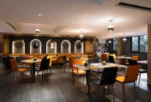 a restaurant with tables and chairs and mirrors at Arthur Hotel Canton Tower Guangzhou-广州塔骑士物语酒店 in Guangzhou