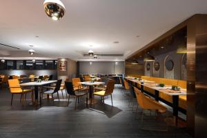 a restaurant with tables and chairs in a room at Arthur Hotel Canton Tower Guangzhou-广州塔骑士物语酒店 in Guangzhou