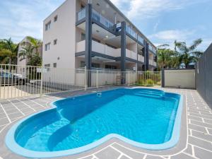a swimming pool in front of a building at Shoal Bay Beach Apartments 18 fantastic air conditioned unit with a pool and lift in Nelson Bay