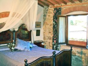 a bedroom with a bed and a window with curtains at Podere Patrignone in Castellina in Chianti